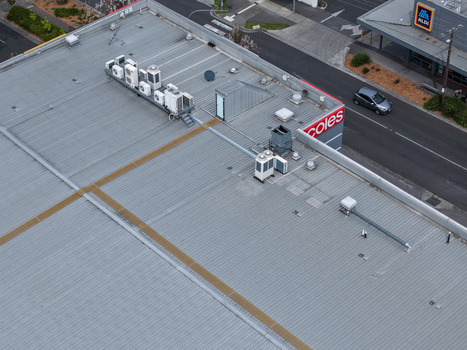 Melbourne Australia 25 September 2026 Aerial view of a commercial building roof with multiple air conditioning units ventilation systems and a nearby road.