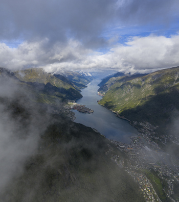 Aerial view of the town of Odda at the end of the Hardangerfjord surrounded by steep mountains and low clouds Odda Vestland Norway. Aerial view of the town of Odda at the end of the Hardangerfjord surrounded by steep mountains and low clouds Odda Vestland Norway.