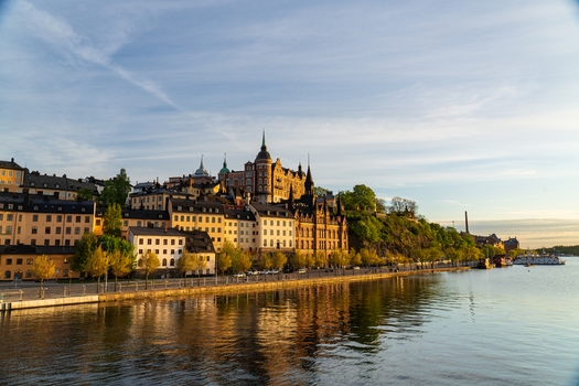 View of the historic Mariaberget district with its colorful buildings and stone walls overlooking the calm water at sunset in Stockholm Stockholms lan Sweden.
