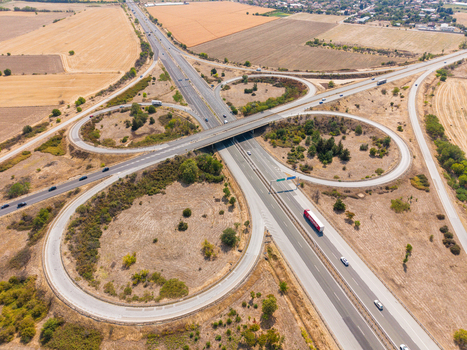 Aerial view of Highway Trakiya interchange with vehicles and trucks driving through the rural landscape in Bulgaria. Aerial view of Highway Trakiya interchange with vehicles and trucks driving through the rural landscape in Bulgaria.