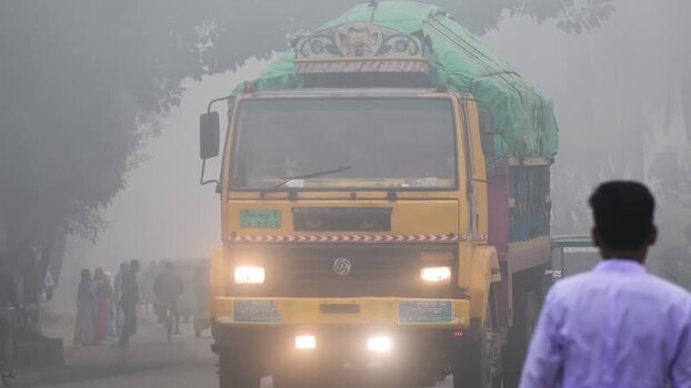View of a yellow truck driving through heavy fog Bangladesh. View of a yellow truck driving through heavy fog Bangladesh.