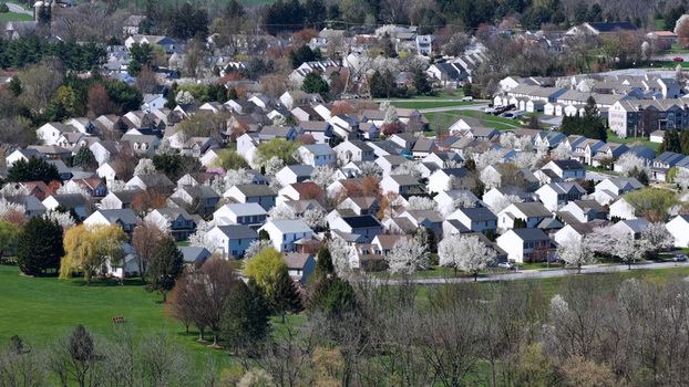 Aerial view of a residential neighborhood in spring with blooming white trees green lawns and paved streets in Lititz Pennsylvania United States.