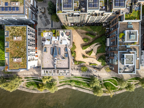 Aerial view of modern apartment buildings with green roofs and a landscaped waterfront park in Hamburg Germany.
