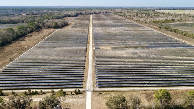 Aerial view of solar panels stretching across the landscape reflecting the sky s pale hue contrasting with the earth tones Elkton Florida United States. Aerial view of solar panels stretching across the landscape reflecting the sky s pale hue contrasting with the earth tones Elkton Florida United States.