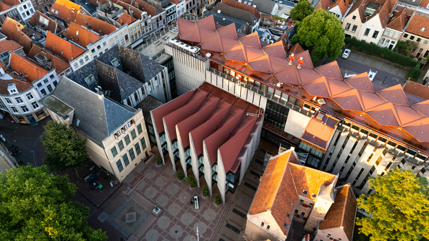 Aerial view of the modern Museum de Fundatie with its distinctive elliptical roof surrounded by historic buildings and rooftops in the city center of Zwolle Overijssel Netherlands.