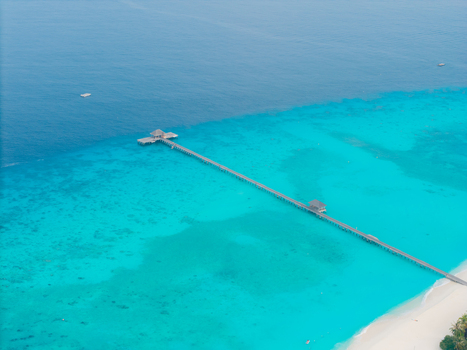 Aerial view of a wooden pier stretching into turquoise waters contrasting with the deep blue sea Hoarafushi Thiladhunmathee Uthuruburi Maldives. Aerial view of a wooden pier stretching into turquoise waters contrasting with the deep blue sea Hoarafushi Thiladhunmathee Uthuruburi Maldives.