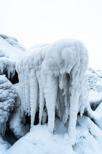 View of the ice covered Molenfeuer Sassnitz structure with heavy icicles hanging from the concrete surface during a cold winter day in Sassnitz Mecklenburg Vorpommern Germany.