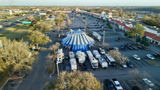 Aerial view of a striking blue and white circus tent standing out against the muted tones of parked RVs and the surrounding urban landscape St. Augustine Florida United States. Aerial view of a striking blue and white circus tent standing out against the muted tones of parked RVs and the surrounding urban landscape St. Augustine Florida United States.