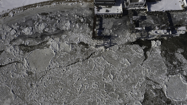 Aerial view of ice floes covering the surface of the water near wooden piers and residential buildings along the shoreline in Highlands New Jersey United States. Aerial view of ice floes covering the surface of the water near wooden piers and residential buildings along the shoreline in Highlands New Jersey United States.