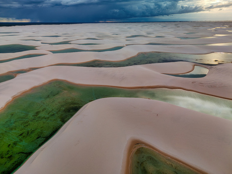 Aerial view of Lagoa Bonita featuring white sand dunes and vibrant turquoise lagoons under a dramatic dark storm sky in Barreirinhas State of Maranhao Brazil. Aerial view of Lagoa Bonita featuring white sand dunes and vibrant turquoise lagoons under a dramatic dark storm sky in Barreirinhas State of Maranhao Brazil.