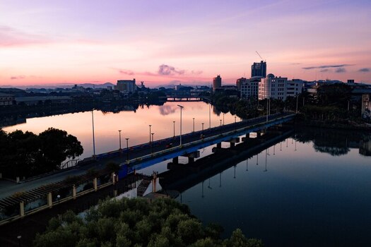 Aerial view of the bridge over the Iloilo river reflecting the pastel sunrise alongside the city buildings Iloilo City Western Visayas Philippines. Aerial view of the bridge over the Iloilo river reflecting the pastel sunrise alongside the city buildings Iloilo City Western Visayas Philippines.