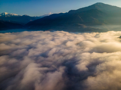 Aerial view of a thick sea of clouds covering the valley with dark mountain peaks under a clear sky at sunrise Muzaffarabad Azad Kashmir Pakistan. Aerial view of a thick sea of clouds covering the valley with dark mountain peaks under a clear sky at sunrise Muzaffarabad Azad Kashmir Pakistan.