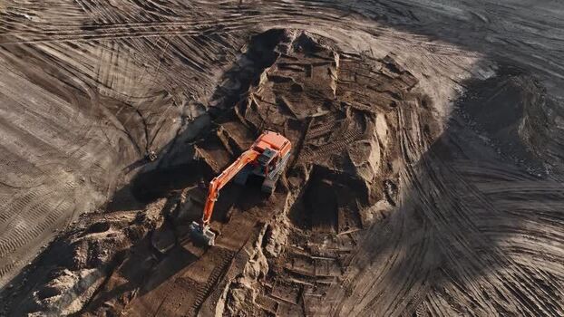 Aerial view of an orange excavator at a construction site Netherlands.