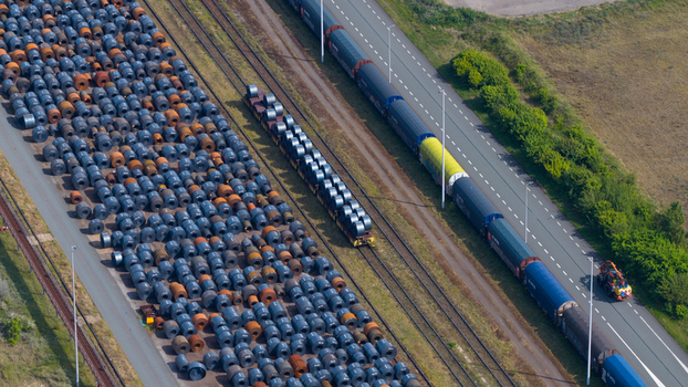 Aerial view of the Tata Steel industrial site featuring rows of steel coils railway tracks with a freight train and a road in Velsen Noord Noord Holland Netherlands. Aerial view of the Tata Steel industrial site featuring rows of steel coils railway tracks with a freight train and a road in Velsen Noord Noord Holland Netherlands.