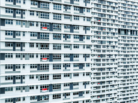 Aerial view of high rise HDB public housing blocks with white and grey facades and Singapore flags displayed from windows in Singapore Singapore. Aerial view of high rise HDB public housing blocks with white and grey facades and Singapore flags displayed from windows in Singapore Singapore.