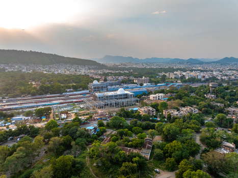 Aerial view of the railway station and surrounding urban landscape with lush greenery and distant hills in Udaipur Rajasthan India. Aerial view of the railway station and surrounding urban landscape with lush greenery and distant hills in Udaipur Rajasthan India.