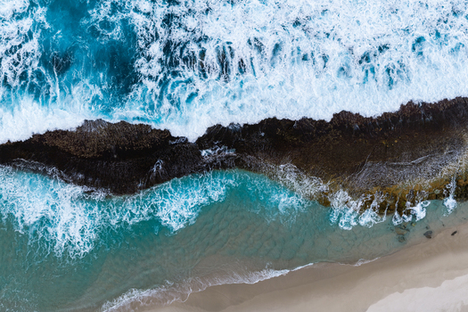 Aerial view of waves crashing against the rocky coastline and sandy shore in Torndirrup Western Australia Australia. Aerial view of waves crashing against the rocky coastline and sandy shore in Torndirrup Western Australia Australia.