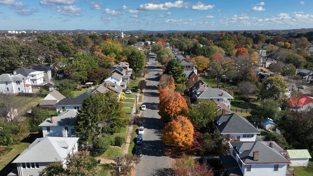 Aerial view of a residential street lined with houses and colorful autumn trees under a clear blue sky in Lynchburg Virginia United States. Aerial view of a residential street lined with houses and colorful autumn trees under a clear blue sky in Lynchburg Virginia United States.