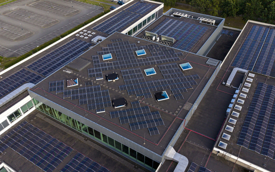 Aerial view of High Tech Campus Eindhoven featuring extensive solar panel arrays on the roof skylights and adjacent parking facilities in Eindhoven Noord Brabant Netherlands. Aerial view of High Tech Campus Eindhoven featuring extensive solar panel arrays on the roof skylights and adjacent parking facilities in Eindhoven Noord Brabant Netherlands.