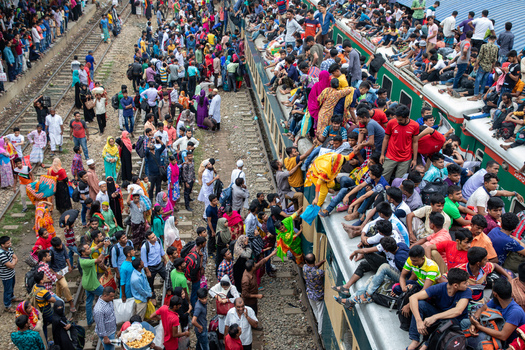 Dhaka Bangladesh 15 June 2018 View of a massive crowd of passengers boarding and sitting on the roof of a train at Airport Railway Station during the Eid al Fitr rush. Dhaka Bangladesh 15 June 2018 View of a massive crowd of passengers boarding and sitting on the roof of a train at Airport Railway Station during the Eid al Fitr rush.