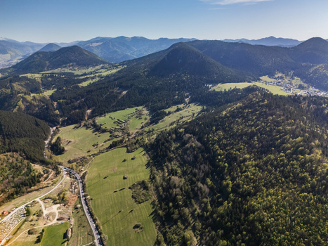 Aerial view of lush green mountains and the village of Valaska Dubova in a valley with winding roads and dense forests under a clear sky in Valaska Dubova Zilina Region Slovakia. Aerial view of lush green mountains and the village of Valaska Dubova in a valley with winding roads and dense forests under a clear sky in Valaska Dubova Zilina Region Slovakia.