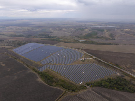 Aerial view of a large solar farm with rows of photovoltaic panels situated in a rural landscape under a cloudy sky in Bulgaria. Aerial view of a large solar farm with rows of photovoltaic panels situated in a rural landscape under a cloudy sky in Bulgaria.