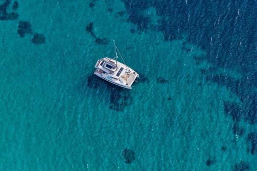 Aerial view of a catamaran sailing in the clear turquoise waters of the Mediterranean Sea near Ile Sainte Marguerite Cannes Provence Alpes Cote d Azur France. Aerial view of a catamaran sailing in the clear turquoise waters of the Mediterranean Sea near Ile Sainte Marguerite Cannes Provence Alpes Cote d Azur France.
