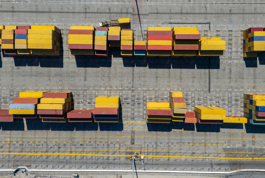 Aerial view of the Port of Long Beach showing rows of colorful shipping containers arranged on the paved terminal ground Long Beach California United States. Aerial view of the Port of Long Beach showing rows of colorful shipping containers arranged on the paved terminal ground Long Beach California United States.