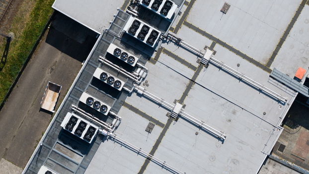 Aerial view of industrial rooftop HVAC units with ventilation fans and complex piping systems on a flat grey roof Utrecht Utrecht Netherlands. Aerial view of industrial rooftop HVAC units with ventilation fans and complex piping systems on a flat grey roof Utrecht Utrecht Netherlands.