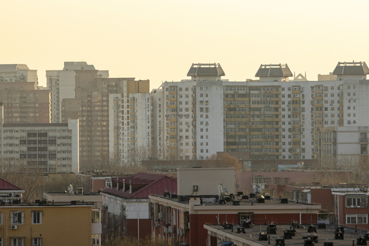 View of high rise residential apartment buildings and urban rooftops under a hazy golden sky Beijing Beijing China. View of high rise residential apartment buildings and urban rooftops under a hazy golden sky Beijing Beijing China.