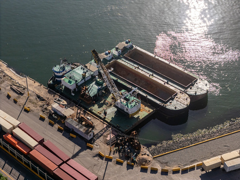 Aerial view of a crane barge docked at the port on the Rio Ozama with shipping containers on the wharf in Santo Domingo Santo Domingo Dominican Republic.