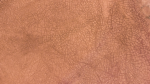 Aerial view of the intricate cracked patterns of a salt pan with textured reddish orange earth in Kalbarri Western Australia Australia. Aerial view of the intricate cracked patterns of a salt pan with textured reddish orange earth in Kalbarri Western Australia Australia.