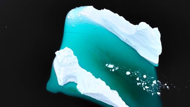 Aerial view of a large iceberg in the dark sea of Greenland. Aerial view of a large iceberg in the dark sea of Greenland.