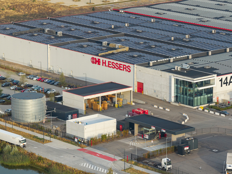 Genk Belgium 27 August 2026 Aerial view of the H.Essers logistics center featuring a large industrial warehouse with rooftop solar panels parking area and freight transport. Genk Belgium 27 August 2026 Aerial view of the H.Essers logistics center featuring a large industrial warehouse with rooftop solar panels parking area and freight transport.