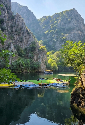 View of kayaks moored at a floating dock in the calm waters of Matka Canyon surrounded by steep rocky cliffs and lush greenery in Skopje Greater Skopje North Macedonia.