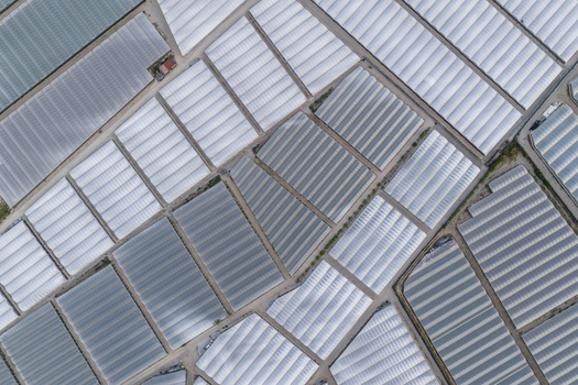 Aerial view of geometric patterns of greenhouses and agricultural polytunnels covering the landscape in Paestum Campania Italy.