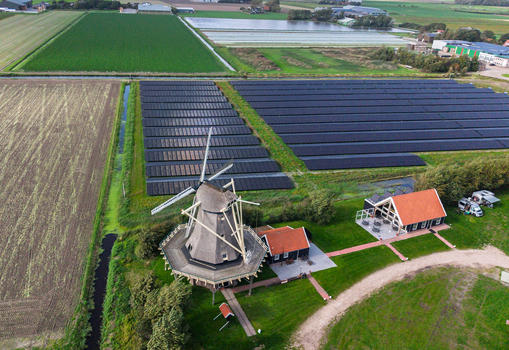 Aerial view of Molen De Hoop windmill surrounded by a large solar farm and green agricultural fields in t Zand North Holland Netherlands. Aerial view of Molen De Hoop windmill surrounded by a large solar farm and green agricultural fields in t Zand North Holland Netherlands.