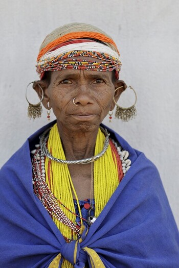 Odisha India 26 March 2026 View of a tribal woman adorned in vibrant yellow beads intricate silver jewelry and a striking blue shawl against a stark white backdrop. Odisha India 26 March 2026 View of a tribal woman adorned in vibrant yellow beads intricate silver jewelry and a striking blue shawl against a stark white backdrop.