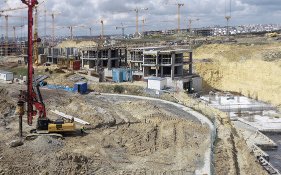 Aerial view of a large construction site with multiple tower cranes concrete building frames and heavy machinery in Sariyer Istanbul Turkiye. Aerial view of a large construction site with multiple tower cranes concrete building frames and heavy machinery in Sariyer Istanbul Turkiye.