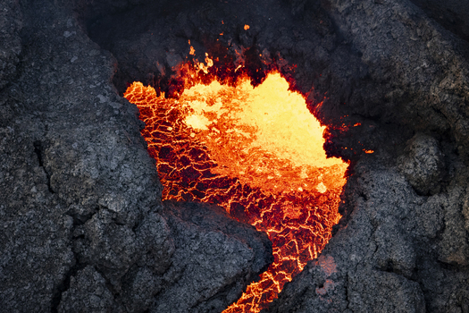 Aerial view of molten lava crackling and glowing against the dark rugged rocks a fiery spectacle of nature s raw power Grindav&iacute;kurb&aelig;r Iceland.