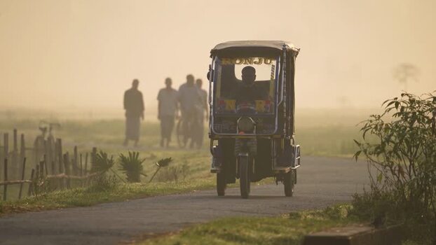 View of a rickshaw driving on a rural road in Bogura Bangladesh.