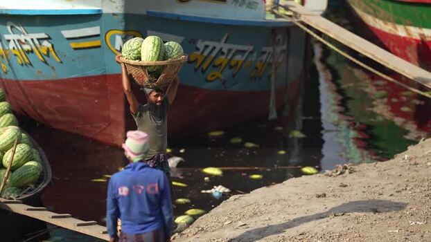 View of a man carrying watermelons at Sadarghat Bangladesh.