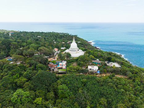 Aerial view of Japanese Peace Pagoda Rumassala surrounded by lush tropical forest and the turquoise ocean in Unawatuna Southern Province Sri Lanka. Aerial view of Japanese Peace Pagoda Rumassala surrounded by lush tropical forest and the turquoise ocean in Unawatuna Southern Province Sri Lanka.