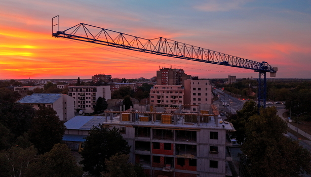 Aerial view of a construction site with a tower crane at sunset featuring residential buildings and urban infrastructure in Pancevo Vojvodina Serbia.