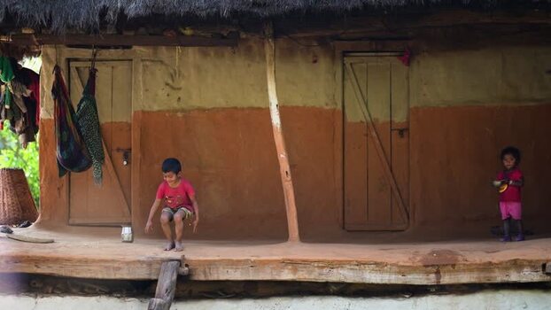 View of children playing on the porch of a mud house Nepal. View of children playing on the porch of a mud house Nepal.