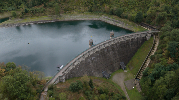 Aerial view of the Sengbachtalsperre dam with its stone masonry wall and reservoir surrounded by dense forest in Solingen Nordrhein Westfalen Germany. Aerial view of the Sengbachtalsperre dam with its stone masonry wall and reservoir surrounded by dense forest in Solingen Nordrhein Westfalen Germany.
