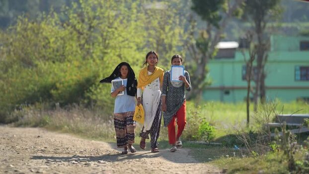 View of three young female students walking along a dirt road Nepal. View of three young female students walking along a dirt road Nepal.