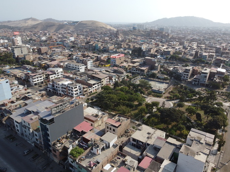 Aerial view of the dense urban landscape featuring residential buildings a central park and surrounding hills in San Juan de Miraflores Lima Peru. Aerial view of the dense urban landscape featuring residential buildings a central park and surrounding hills in San Juan de Miraflores Lima Peru.