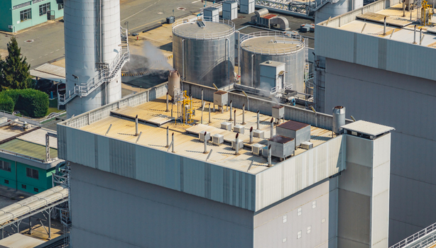 Aerial view of an industrial power generation building featuring rooftop ventilation equipment large storage tanks and steam infrastructure Chivasso Piedmont Italy. Aerial view of an industrial power generation building featuring rooftop ventilation equipment large storage tanks and steam infrastructure Chivasso Piedmont Italy.