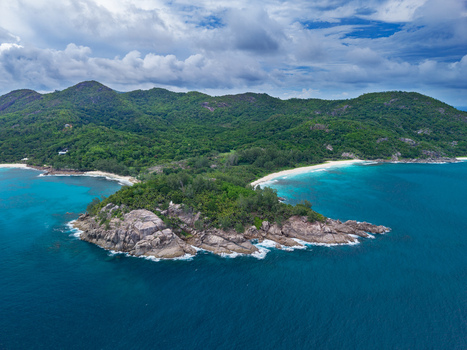 Aerial view of the rocky outcrop meeting the turquoise sea beneath a canopy of verdant hills Mahe Island Seychelles. Aerial view of the rocky outcrop meeting the turquoise sea beneath a canopy of verdant hills Mahe Island Seychelles.